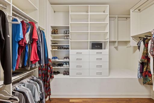 Custom shelving in primary closet with jewelry drawer and hamper
