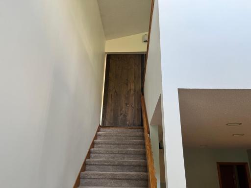 Stairs lead up to primary suite with new barn door entry offering privacy