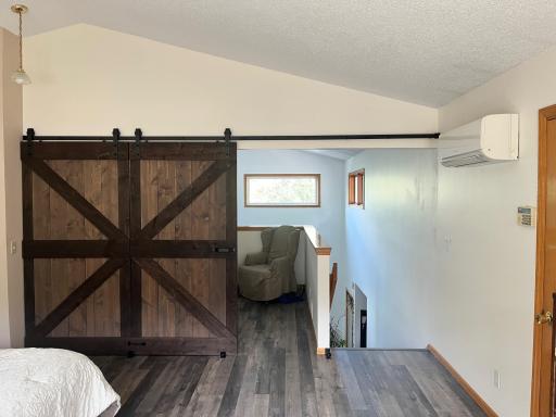 Newly updated primary bedroom framed off the open ceiling & added a new barn door creating a private room