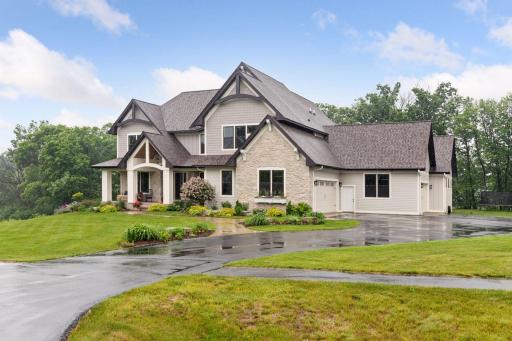 This front view shows the the home's curb appeal: beautiful exterior finishes, a large driveway for parking or activates and its beautiful landscaping.