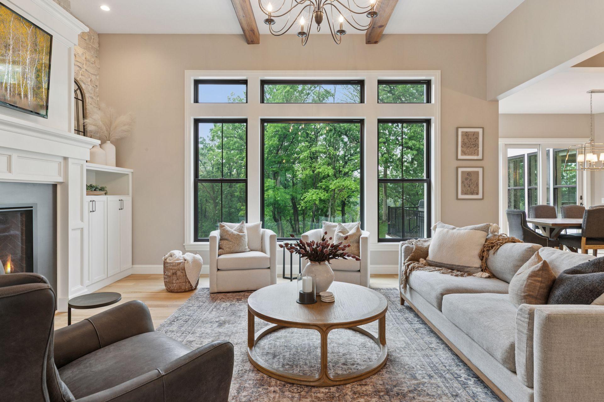 Wall-to-wall windows bring the outdoors in, bathing the space in light and offering unobstructed views of the pool and tranquil tree line.