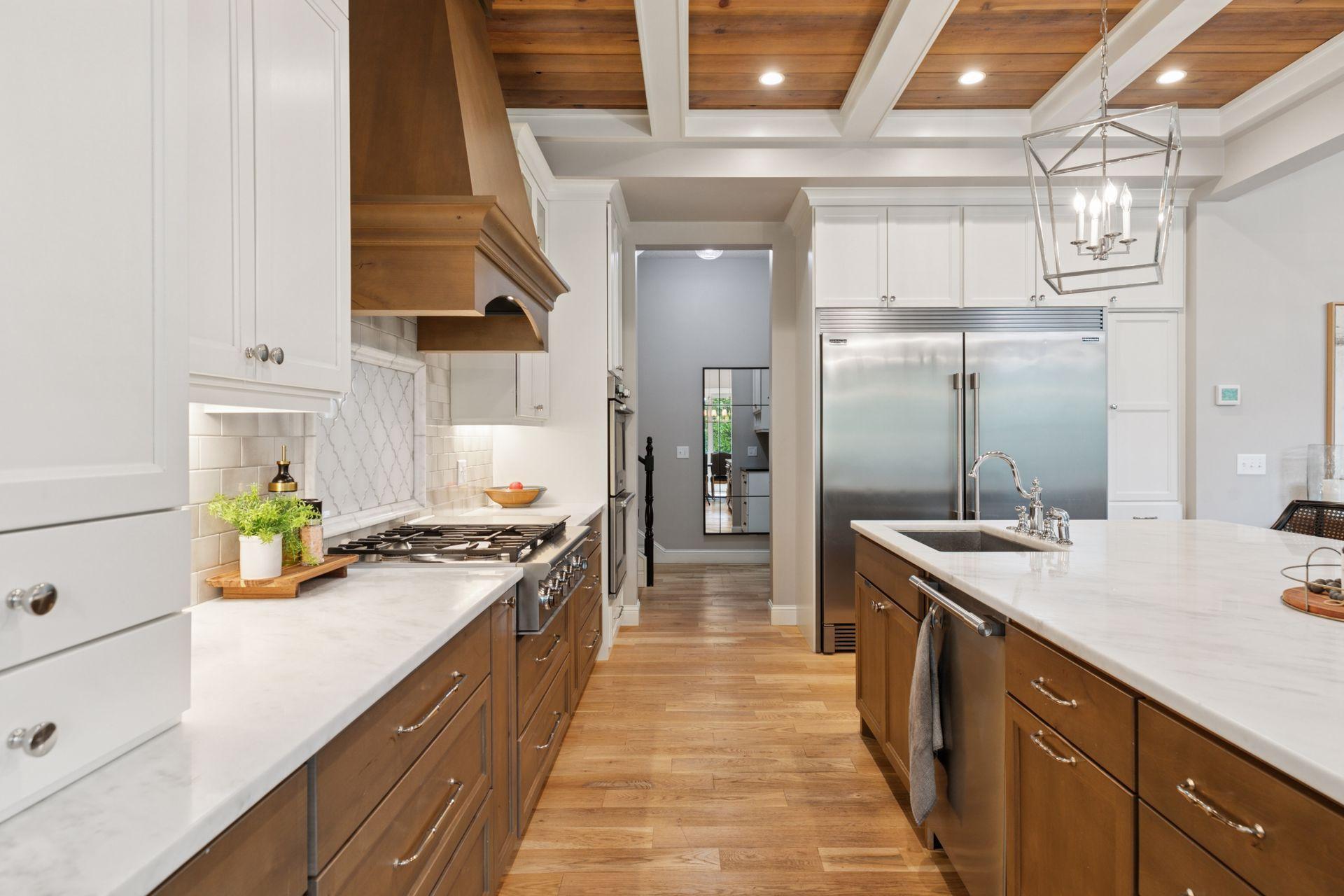 Extended prep and cooking space with professional-grade appliances, custom cabinetry, and seamless access to hallway and secondary rooms.