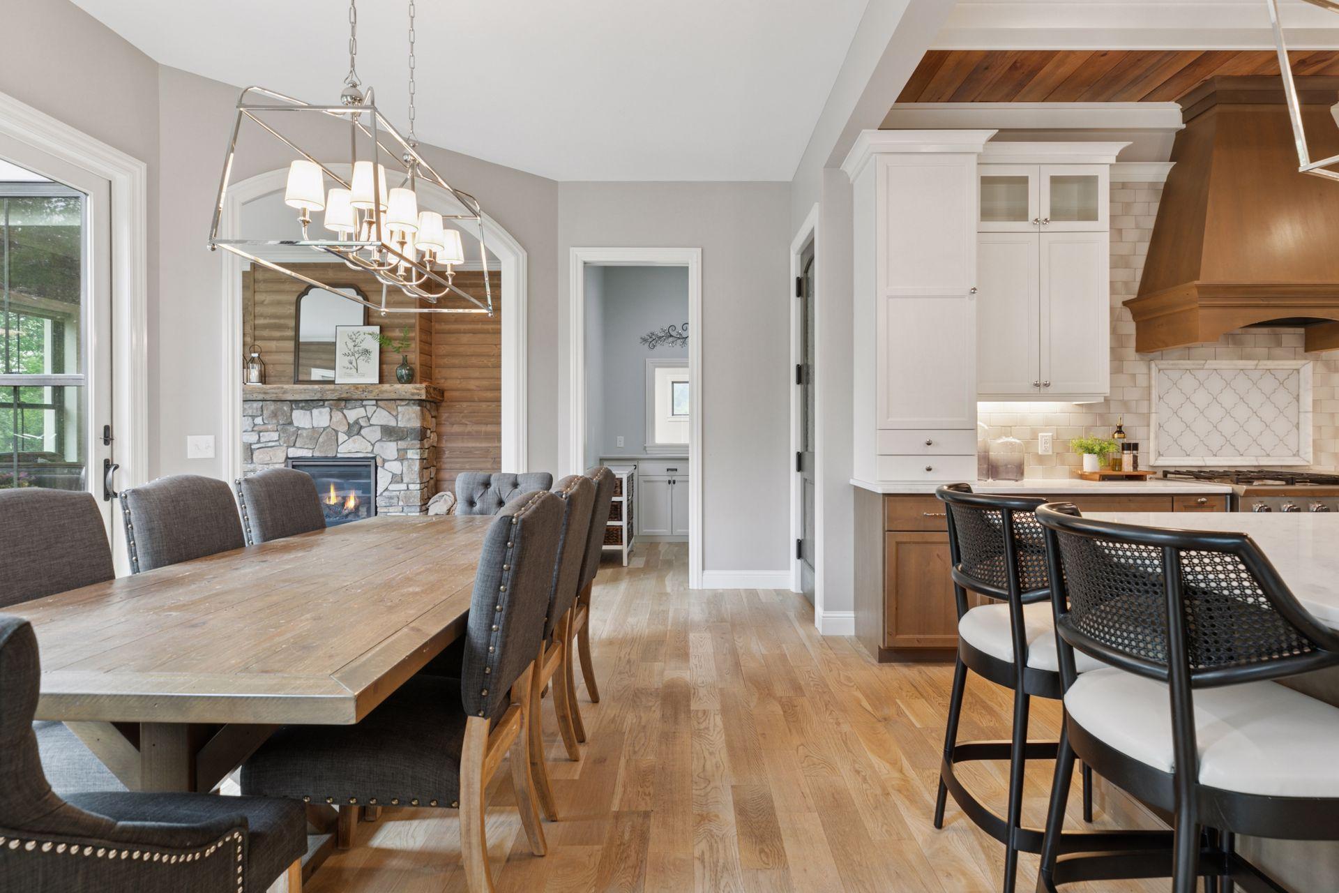 Elegant dining room with seating for ten, positioned to enjoy both backyard views and cozy ambiance from the adjacent stone fireplace.