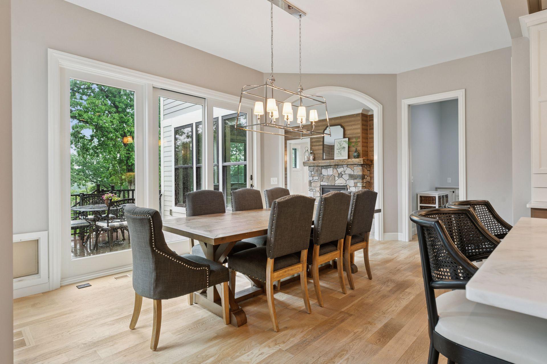 Surrounded by large windows and sliding doors, the dining space offers natural light and easy access to the deck and outdoor living.