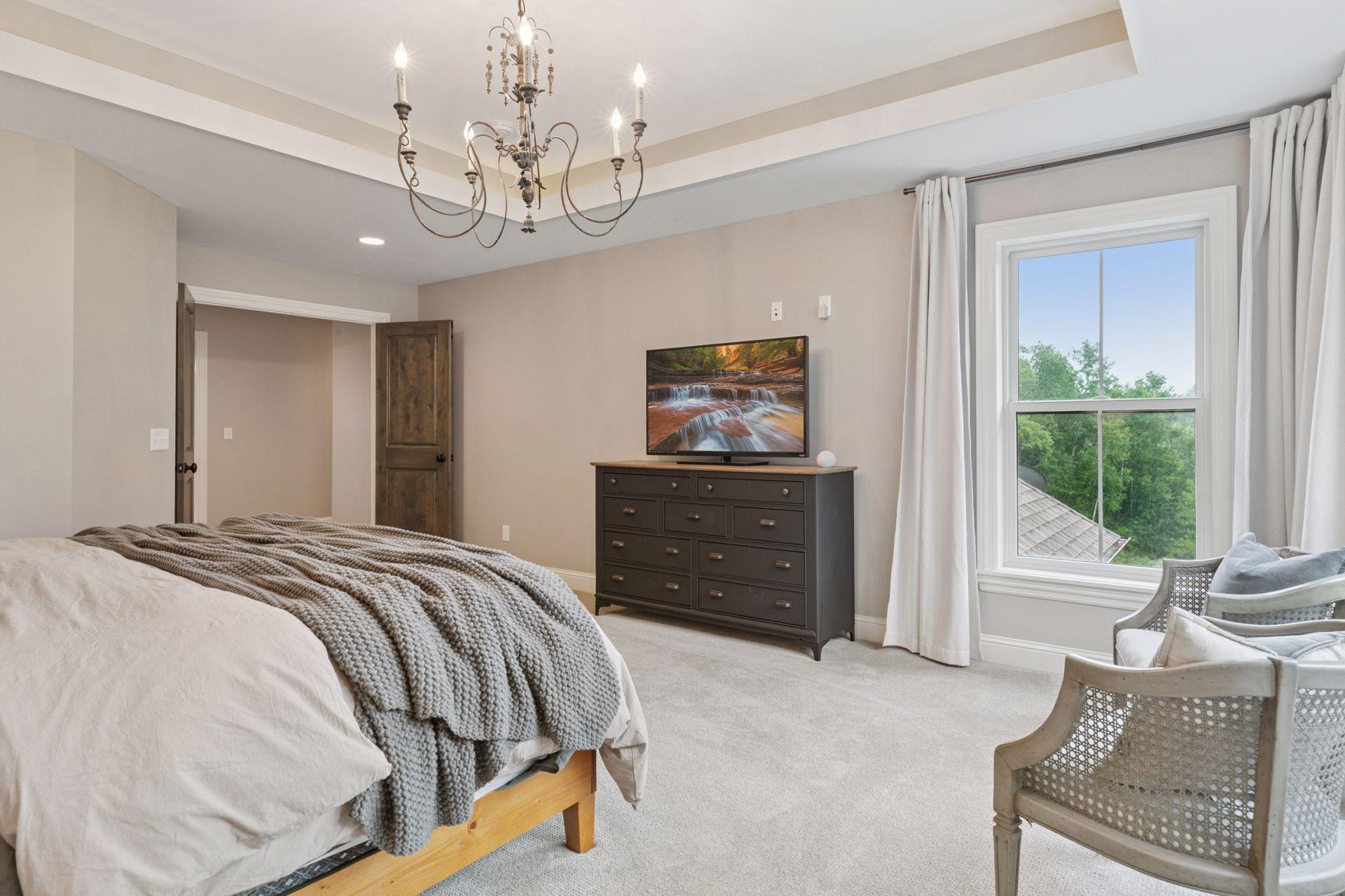 Enjoy serene views and comfort in this expansive suite, complete with elegant window treatments, media setup, and beautiful trim detail.