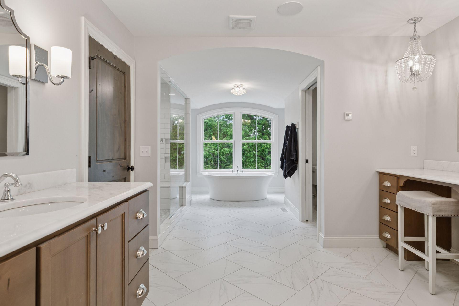 Soak in the serenity from this freestanding soaking tub, perfectly framed by large arched windows and surrounded by natural light.