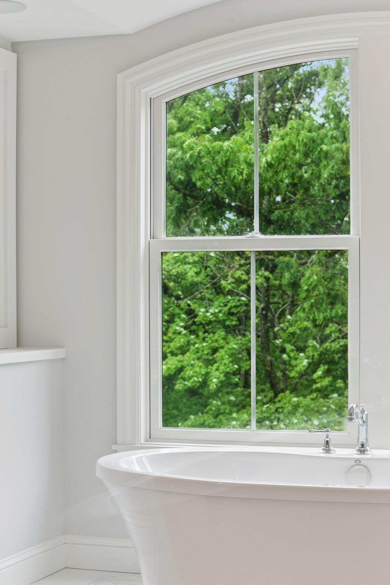 Detailed view of the glass-enclosed walk-in shower, showcasing marble tilework and dual showerheads for a luxurious bathing experience