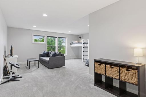 Spacious bonus room with large windows, recessed lighting, and built-in lofted bunk bedsâperfect for lounging or play.