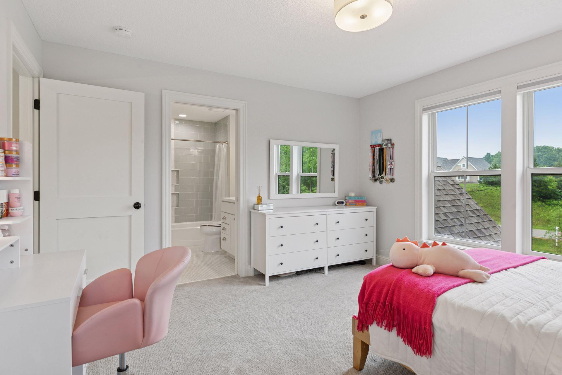 Another angle of the pink-themed bedroom with private en suite bath and vanity.