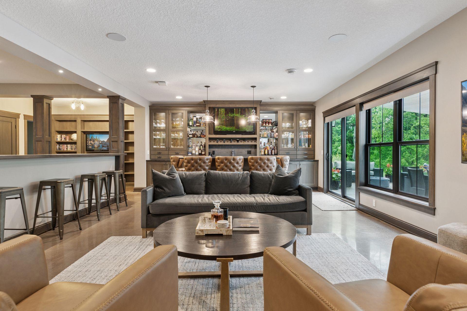 Stylish lower-level bar with built-in shelving, pendant lighting, and easy flow into the family room and outdoor space.