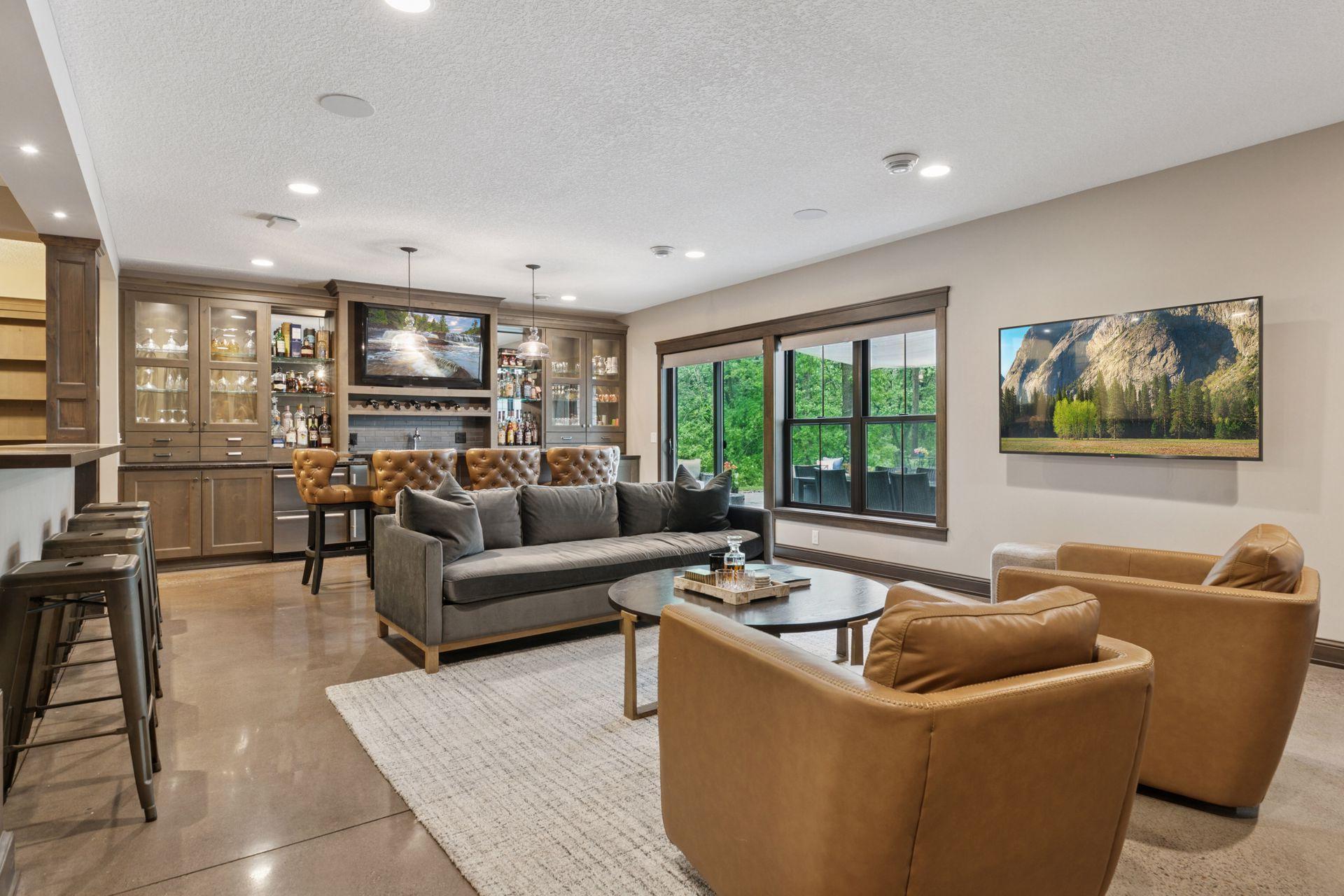 Sleek and fully equipped lower-level wet bar with granite counters, custom cabinetry, dual beverage drawers, and direct walkout access to the patio.