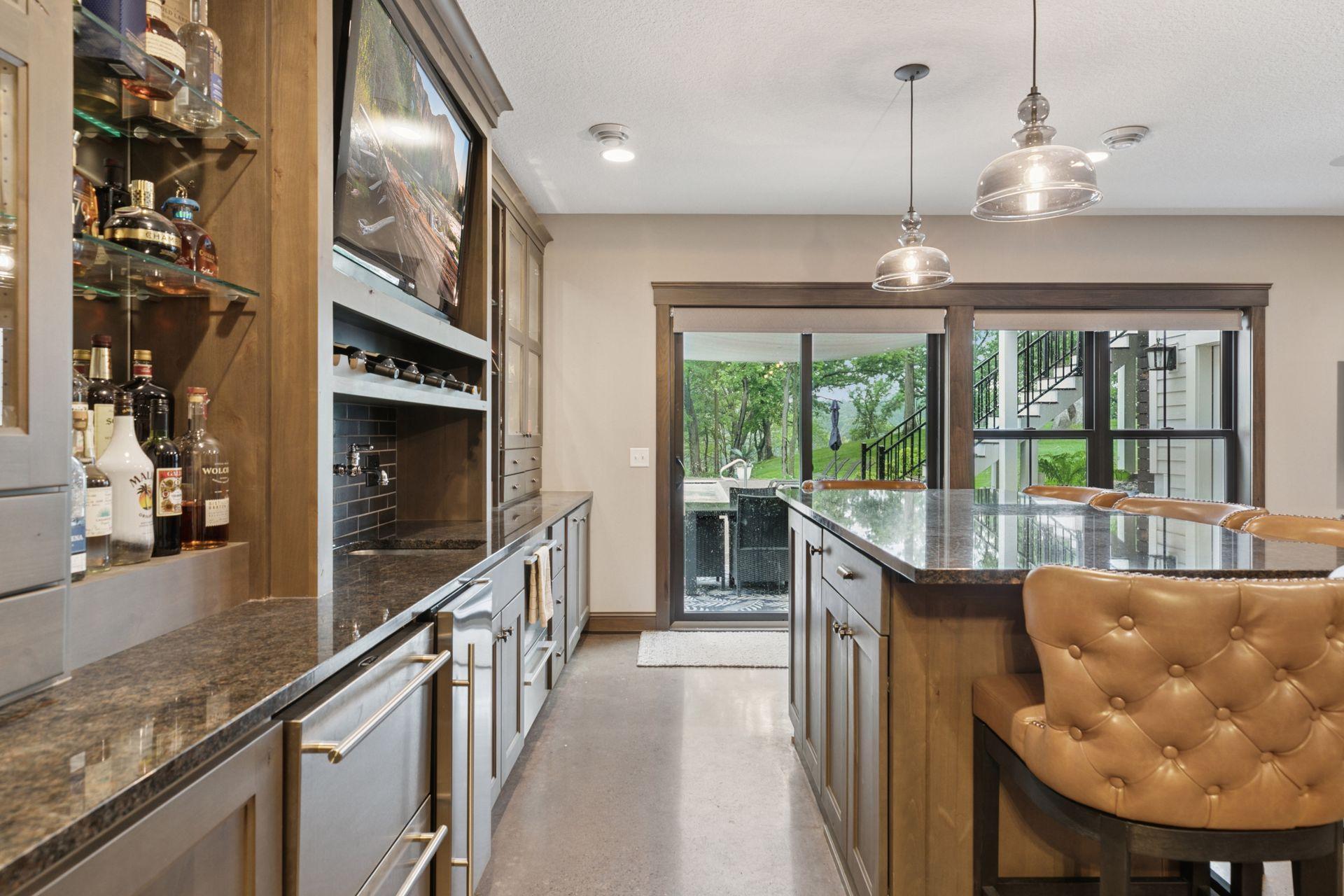 Entertainment-ready media and bar space with theater-style screen, granite bar island, and elegant transitional finishes.