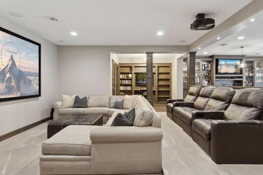 Comfortable home theater with a large screen, sectional seating, and soft carpetâperfect for relaxing and watching movies.