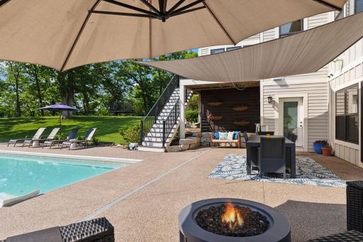 Covered entertaining space features an outdoor dining area, patio seating, and sunshade sails. Ideal for al fresco meals, summer parties, or shaded afternoon lounging.