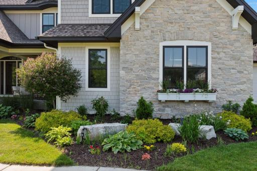 Close-up of stone facade and custom window box with blooming flowersâadds warmth and charm to the front elevation.