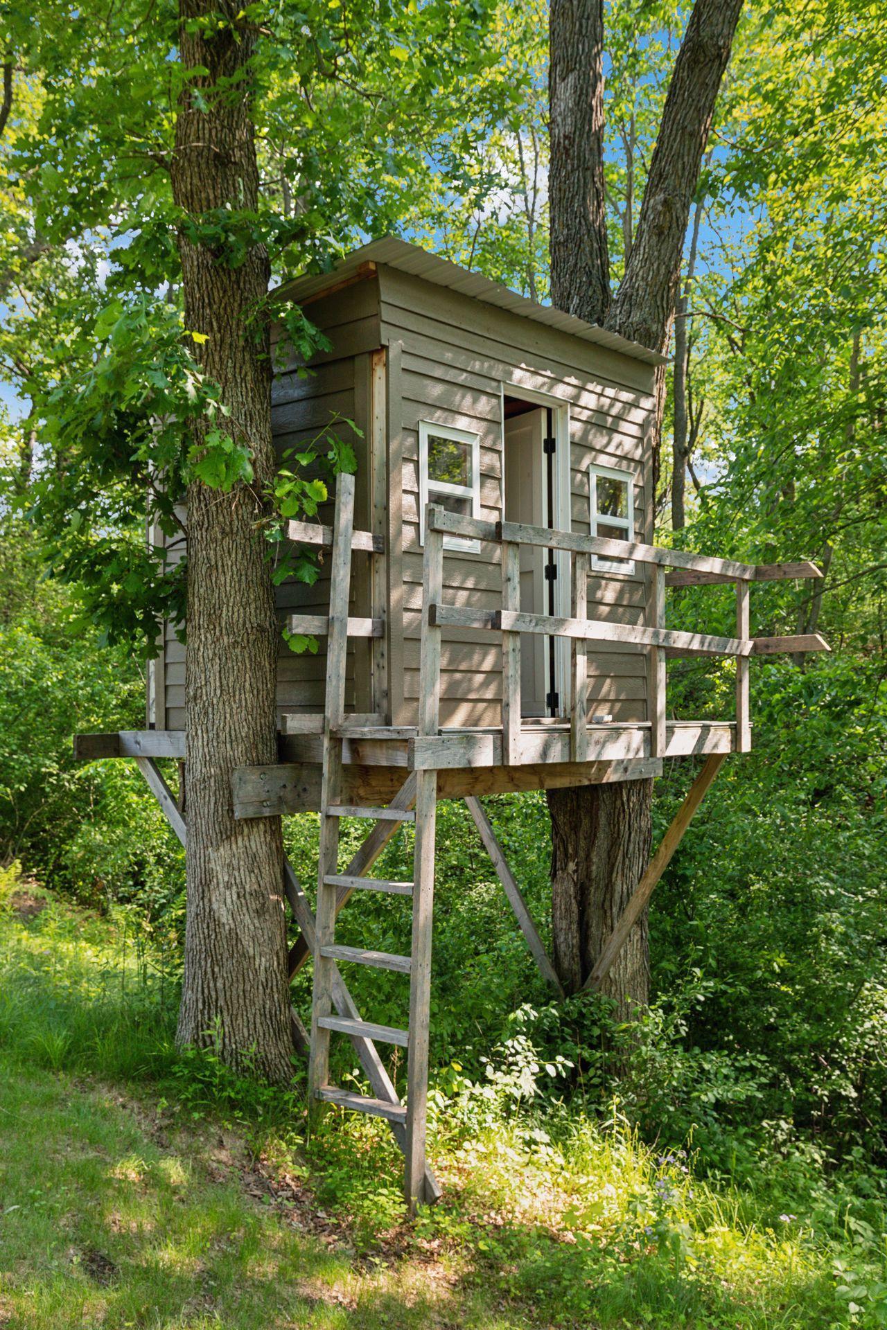 Rustic treehouse nestled among the trees—perfect for kids’ adventures or a quiet reading nook with nature all around.