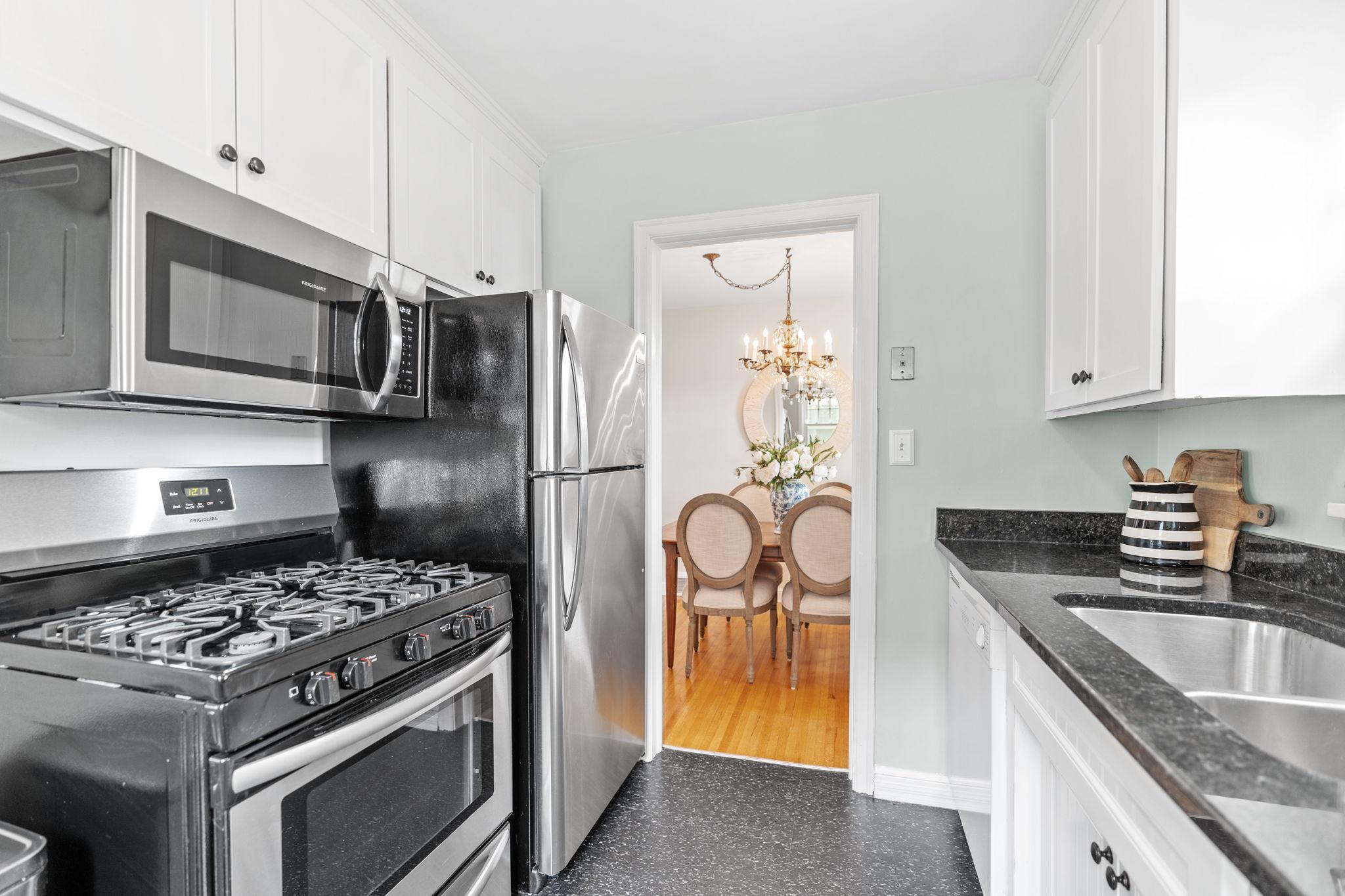 Kitchen includes stainless steel microwave and range. The kitchen also includes a dishwasher with access to the dining room, exterior side door, and lower level.