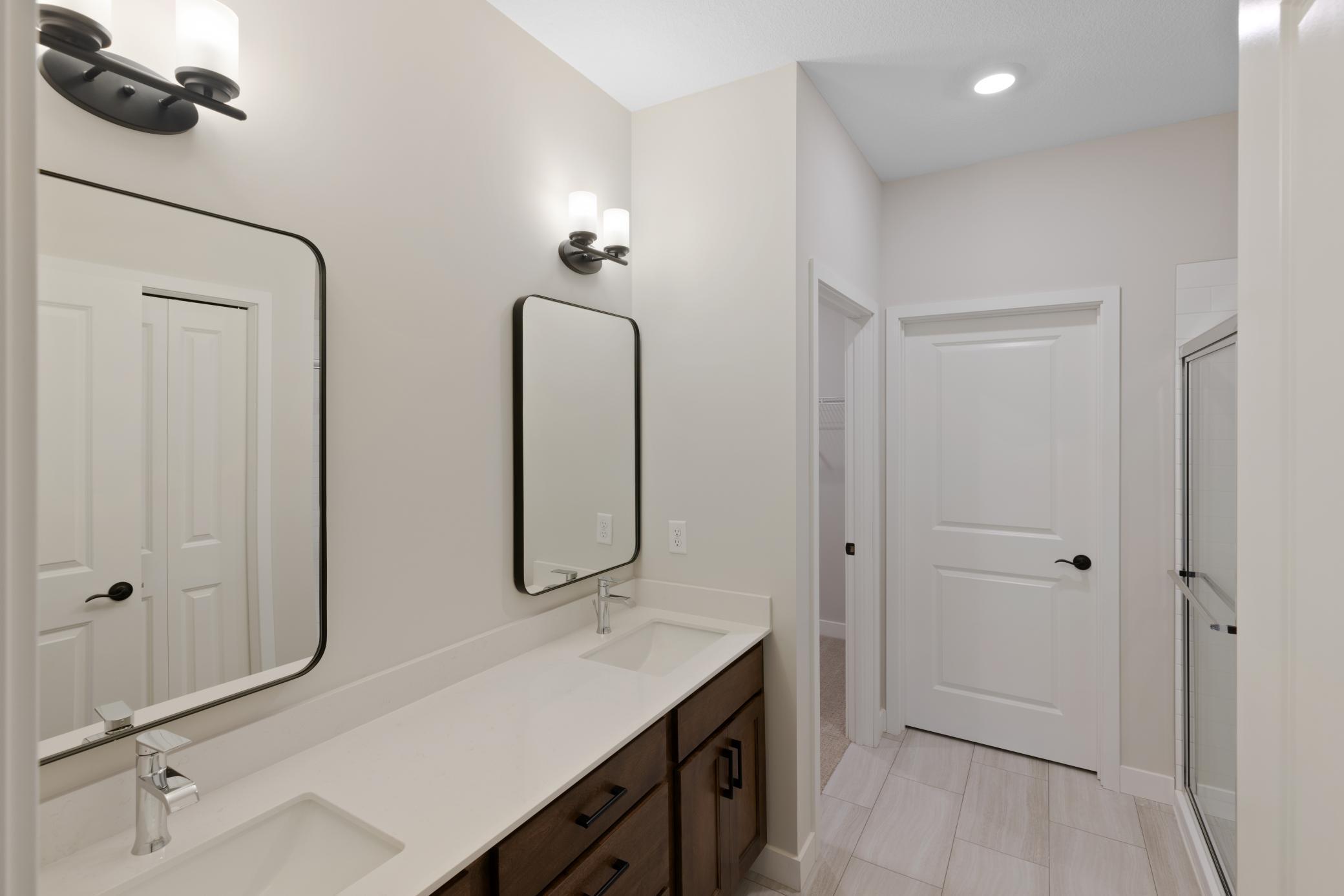 Spacious primary bath features a double vanity for added convenience and a luxurious 5' tiled shower, offering both style and functionality for a relaxing retreat. Perfect for unwinding after a long day. *interior colors/selection may vary.