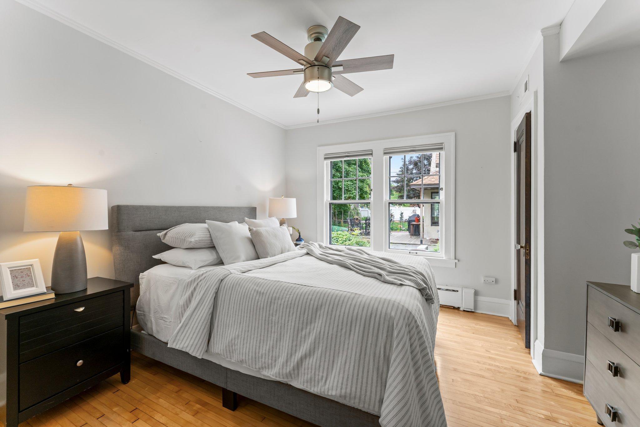 On the main level, you'll also find a spacious bedroom with crown molding, hardwood floors, dual closets, and a ceiling fan.