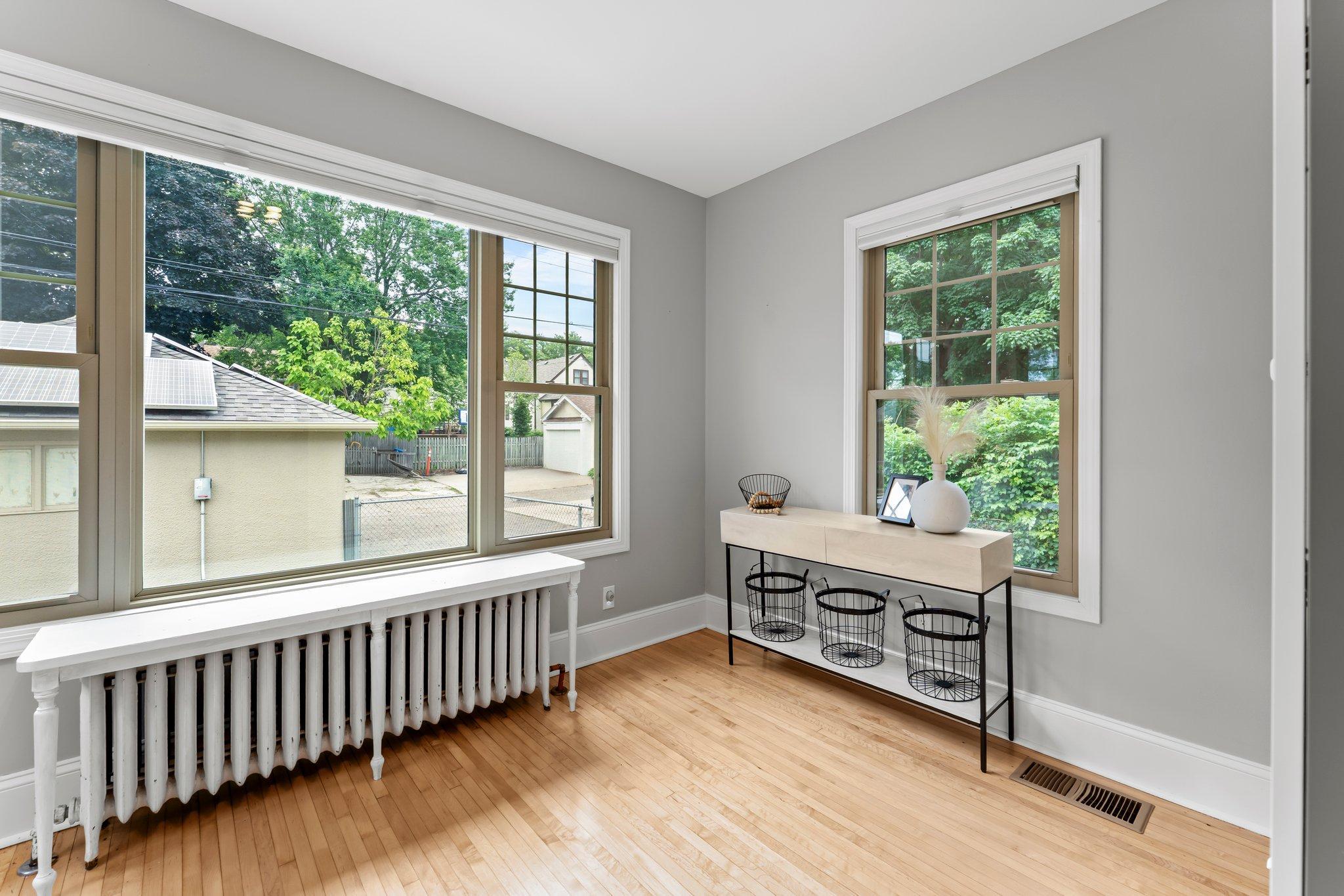 A bright and peaceful sunroom at the back of the home offers serene views of the yard and direct access outside, blending indoor comfort with outdoor living.