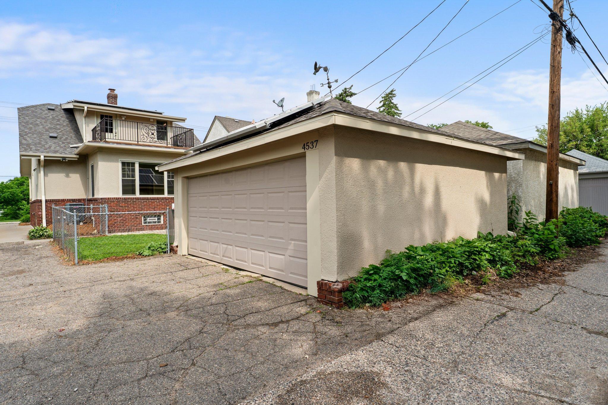 The property also includes a drive-through driveway and a detached two-car garage with a remote opener.