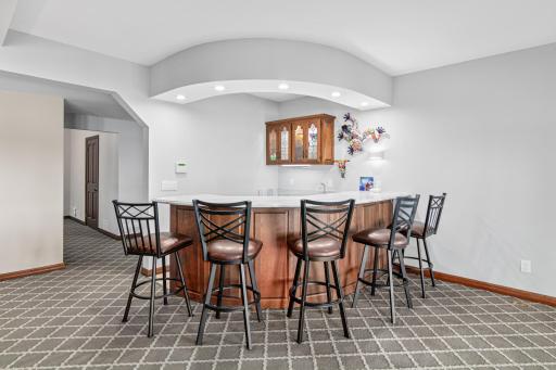 The sleek wet bar is ready for beverages, snacks, or serving up drinks during game night.