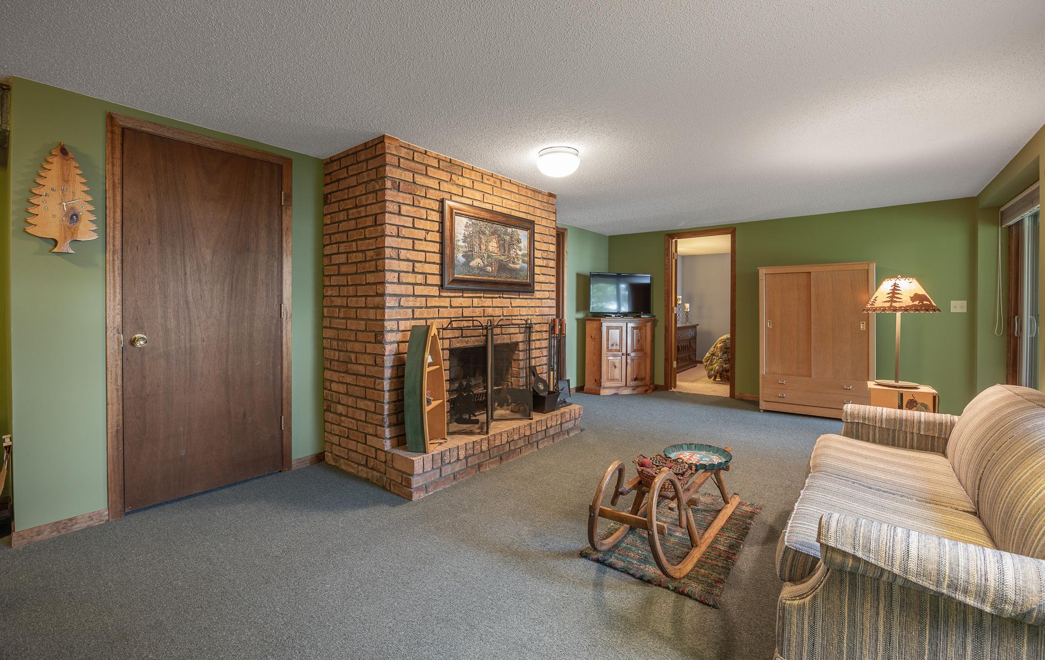 Large wood burning fireplace in lower level of home.