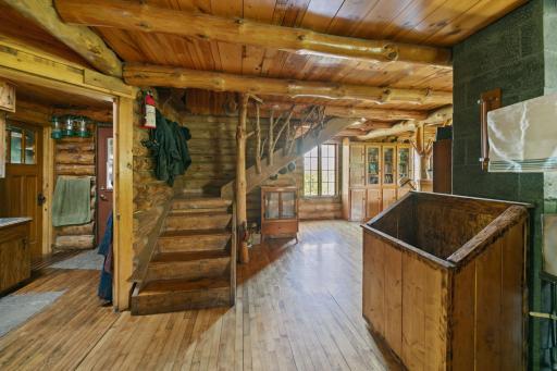Stepping into the main level, you can the craftsmanship in this impressive custom stairwell--Perfect for a log home. The flooring throughout the main level is maple, recovered from a school demolition.