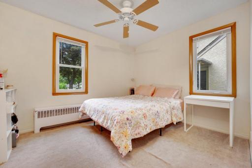 Bright and cozy main level bedroom with double windows and space to unwind or work from home.