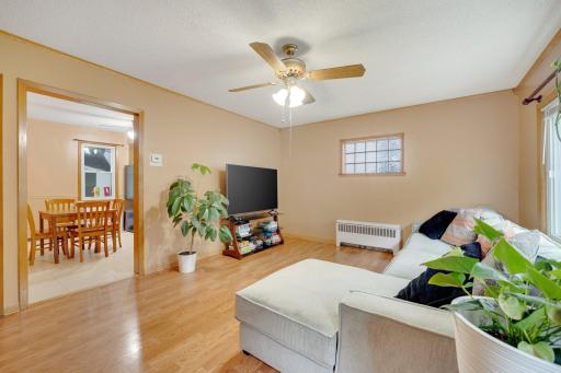 Cozy sun filled living room with natural light and open flow to eat-in kitchen.