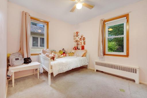 Sunlit and sweet, this cozy bedroom overlooks green views and offers plenty of space for play.
