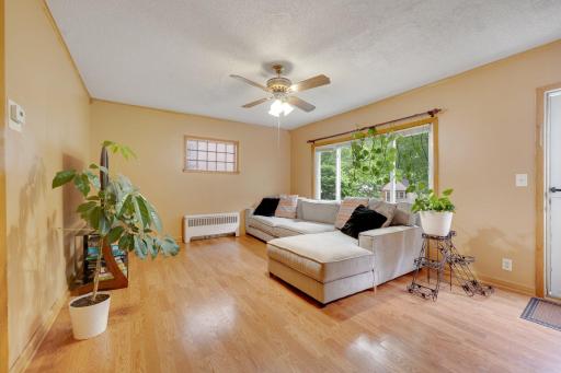 Warm laminate floors and a picture window make this cozy living room feel fresh and inviting.