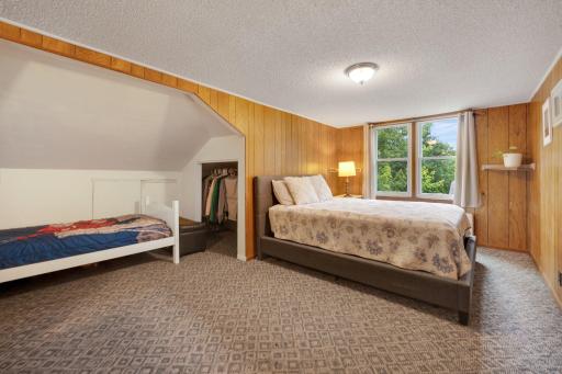 Charming upper-level primary bedroom with cozy nooks, lush views, and plenty of closet space.