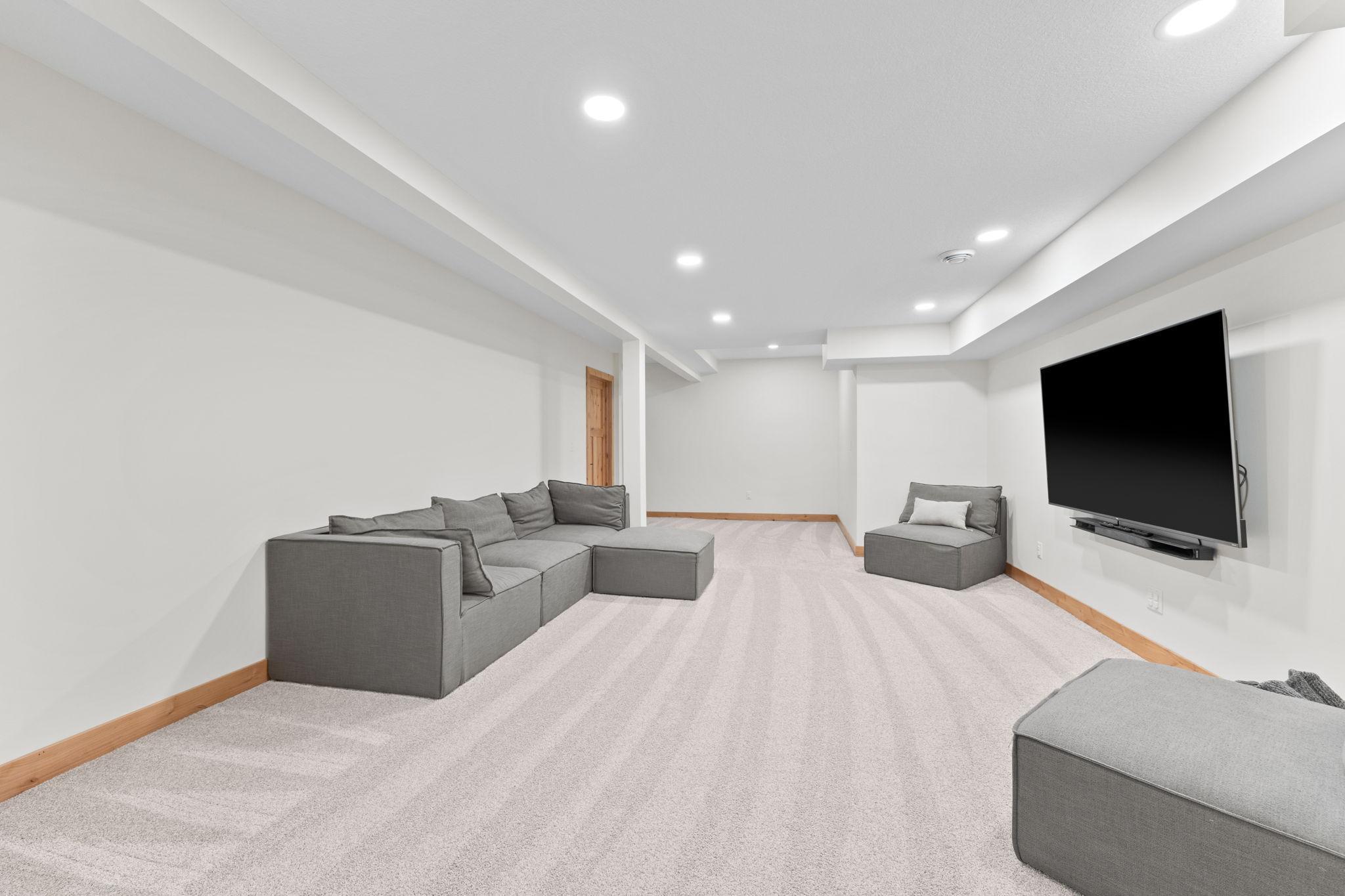 Very spacious lower level family room with plush carpet and recessed lighting.