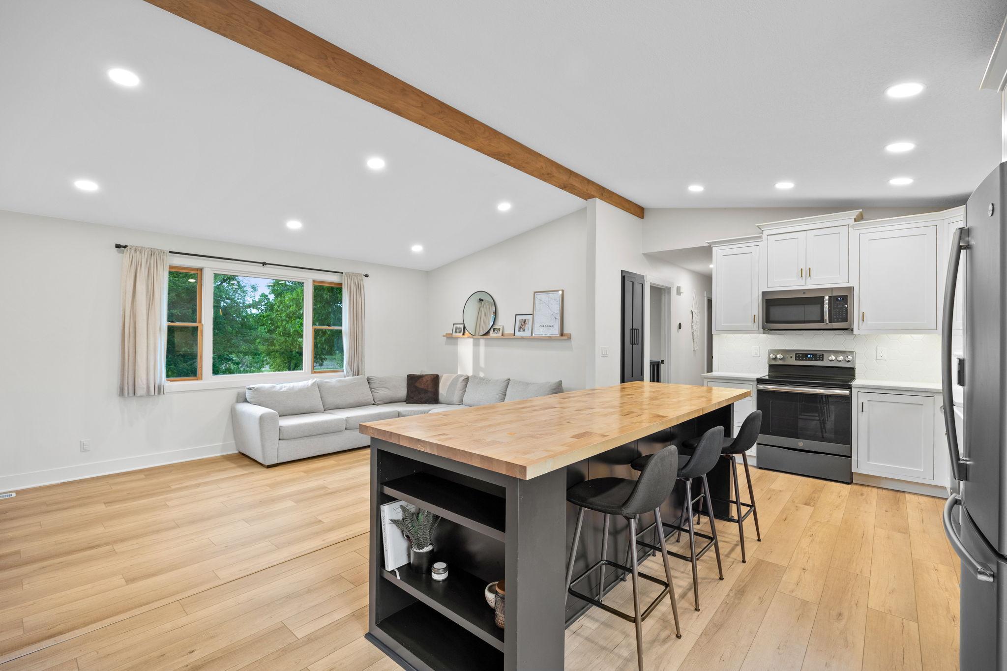 Custom kitchen island with seating on both sides, butcher block countertop, touch-to-open cabinets.