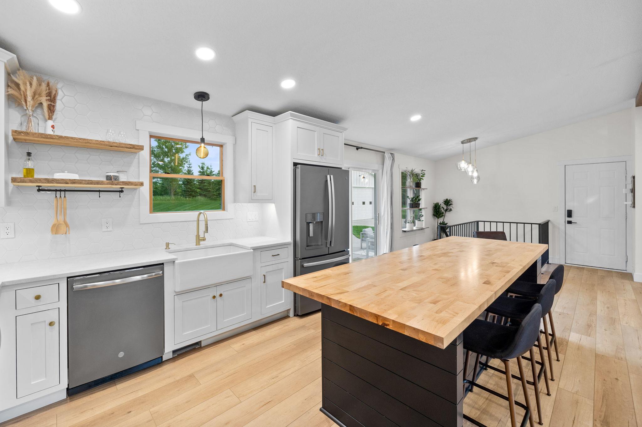 Custom inset cabinetry with pull-outs, under cabinet lighting, quartz countertops.
