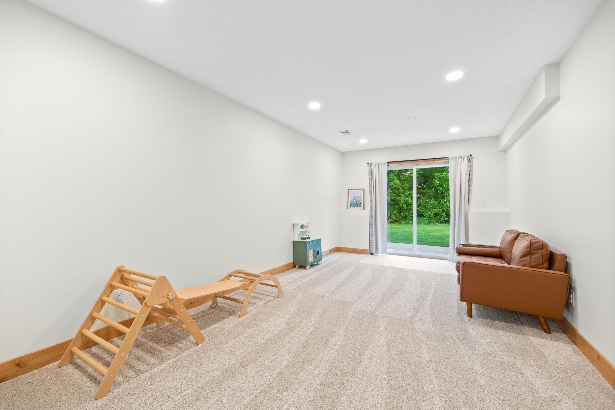 Lower level living room/play space with walk-out to 10x10 concrete patio.