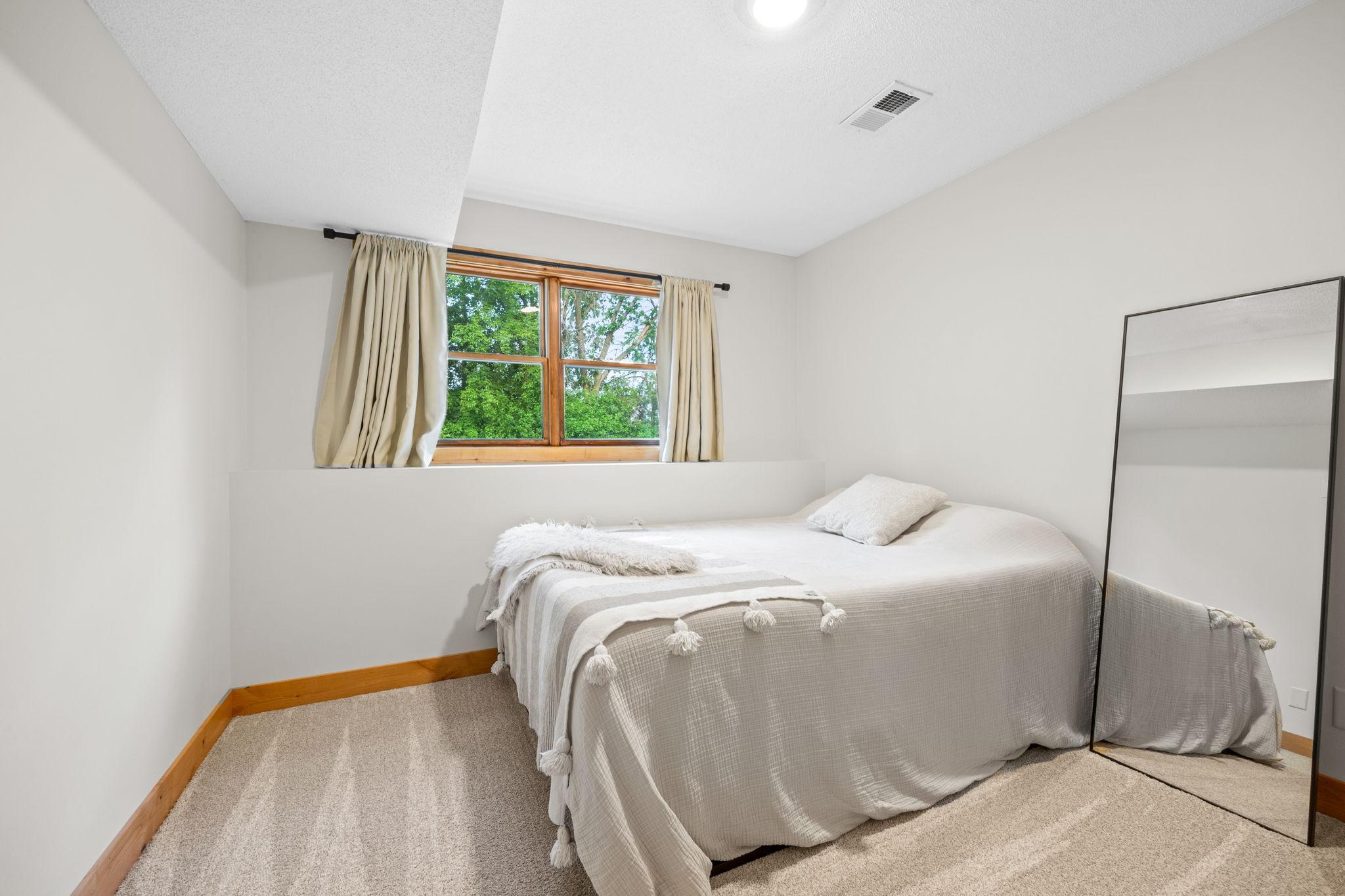 Lower level bedroom with newer knotty alder closet doors.