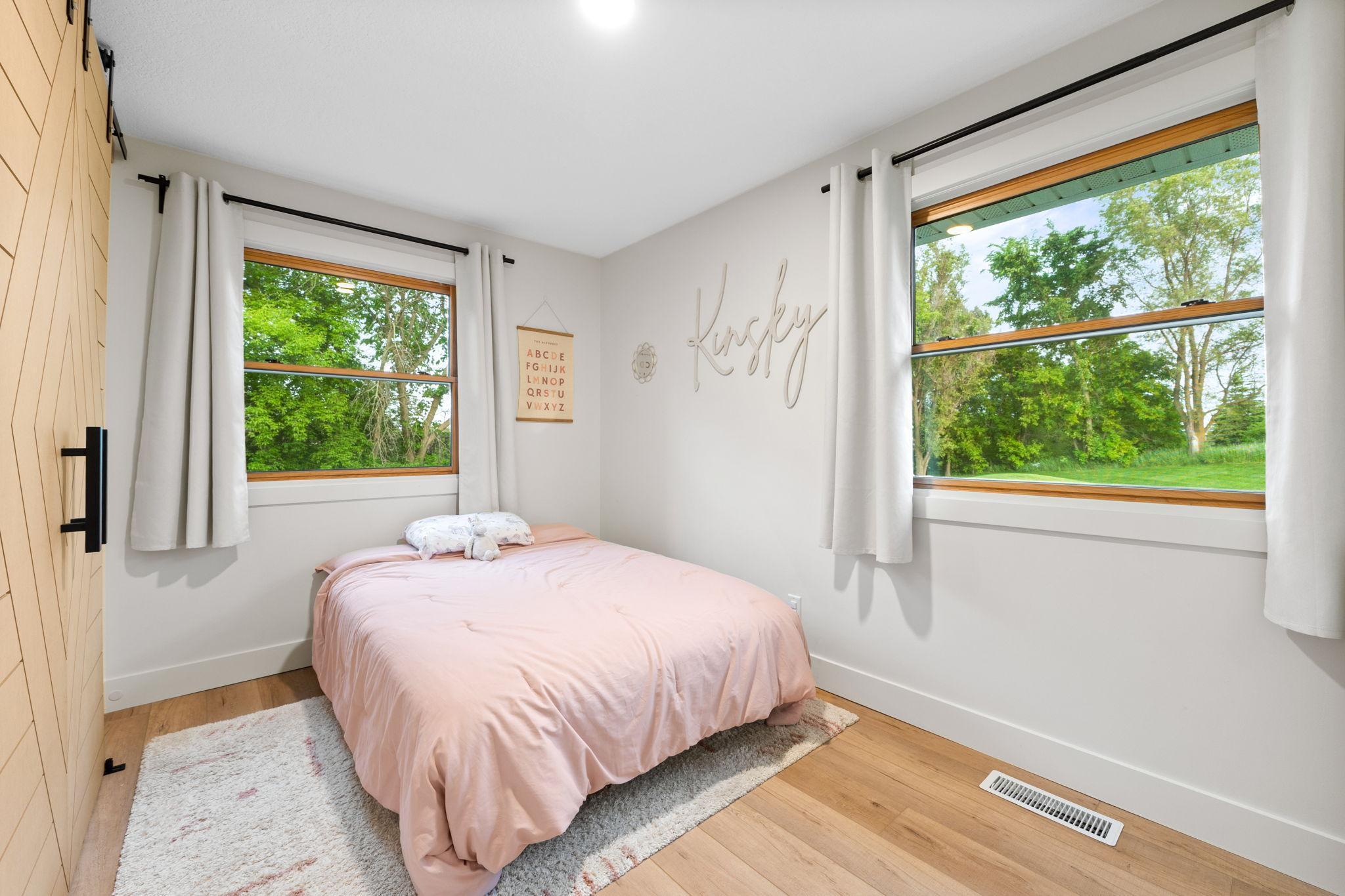 Main level bedroom with custom closet doors and closet organization system.