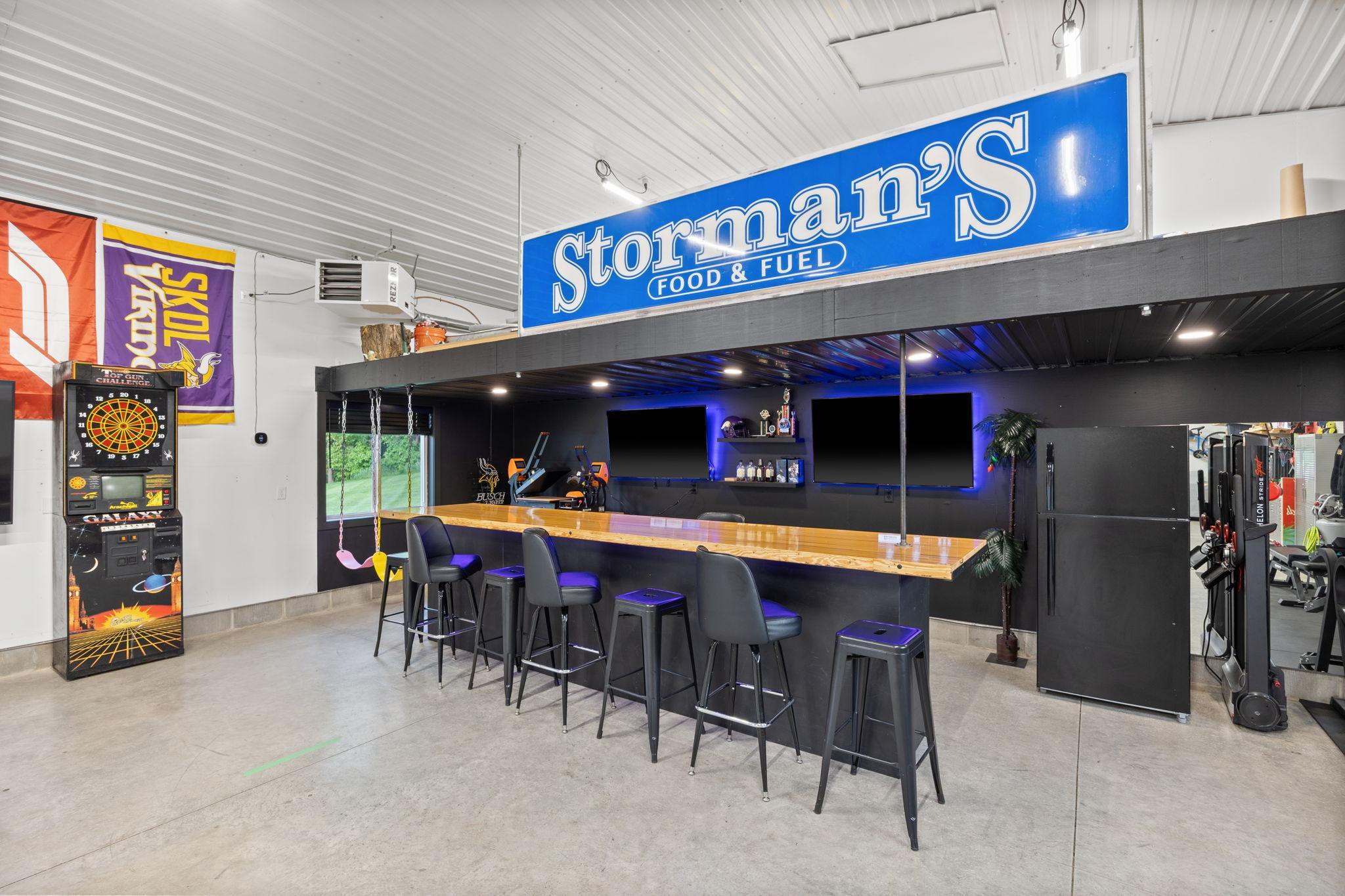 Entertaining bar space under storage loft. Repurposed bowling alley lane countertop, recesssed lighting, under bar lights and TV lights.