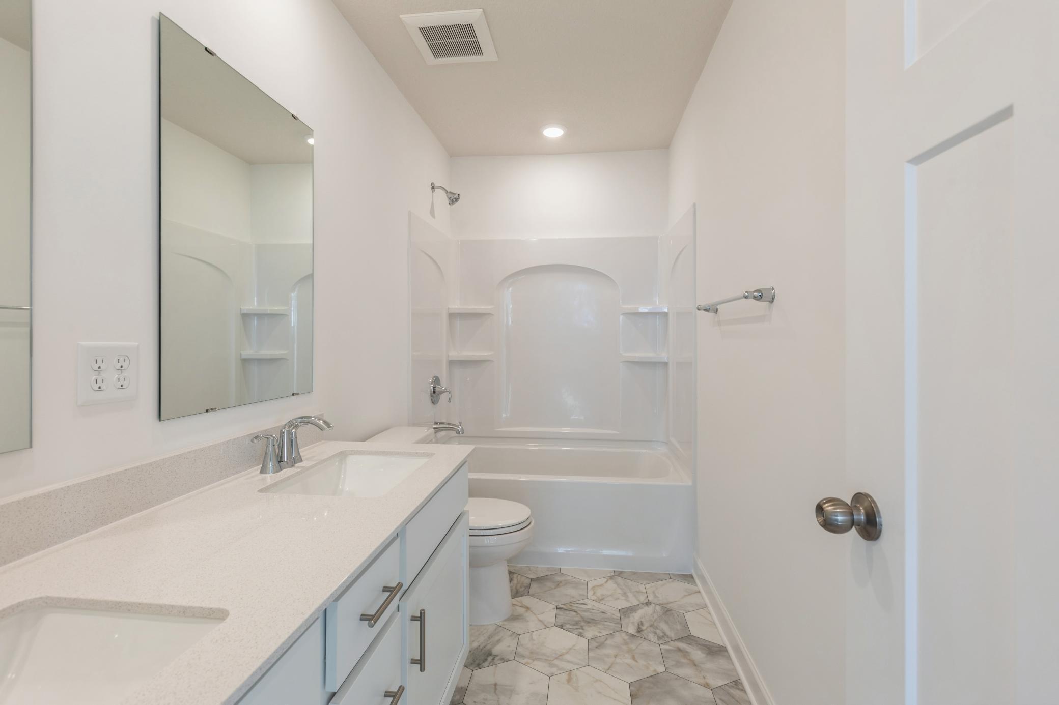 (*Photo of similar home, actual homes colors and finishes will vary) The spacious secondary bathroom