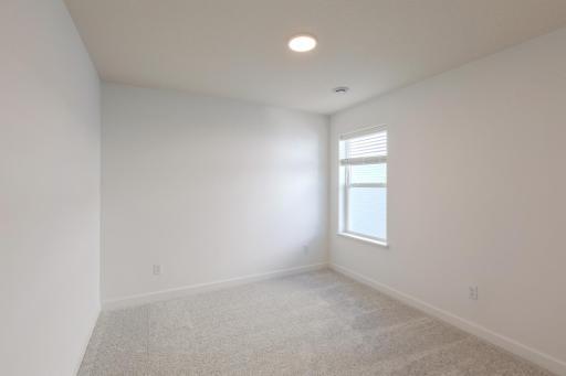 (*Photo of similar home, actual homes colors and finishes will vary) One of the spacious secondary bedrooms