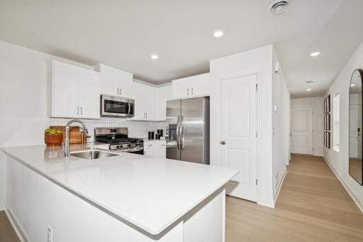 (Photo of the model home) This spacious kitchen features a large island, stainless appliances and more!