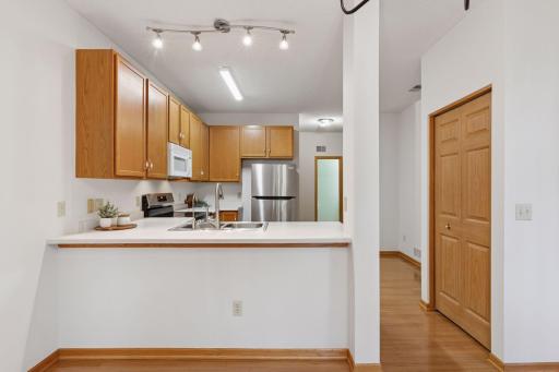 Open sightlines into the kitchen from the dining area, plus a breakfast bar. Very large walk-in pantry behind the doors on the right.