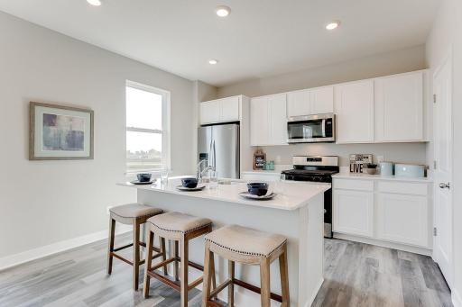 Great eat in kitchen with spacious island and walk in pantry. Photo of model home, color & options will vary.