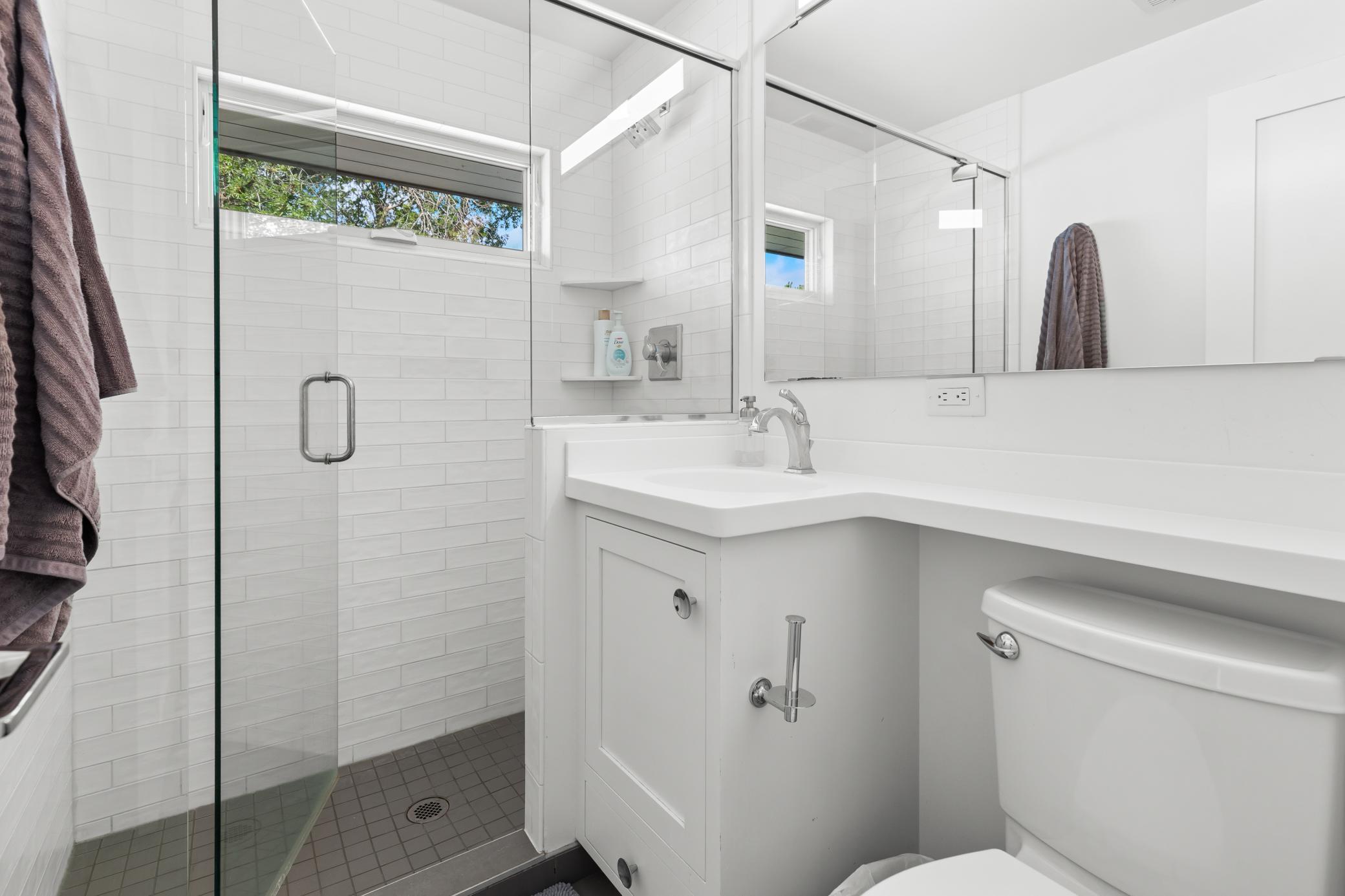 Second level bathroom with Corian countertops and grey mosaic tile [2 bathrooms on the second floor].