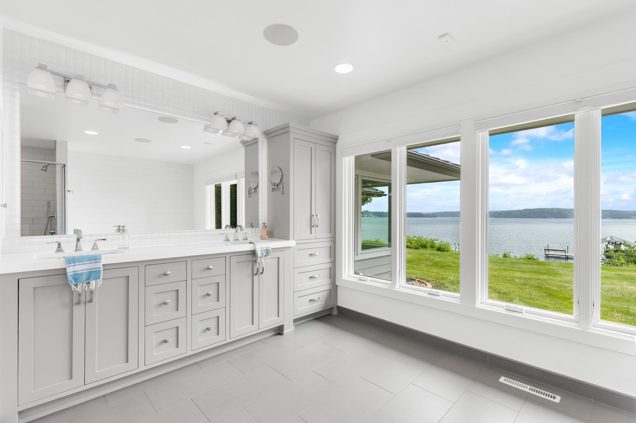 Quartz countertops, double sinks, a heated floor, enameled cabinetry and much more in primary first floor bathroom.