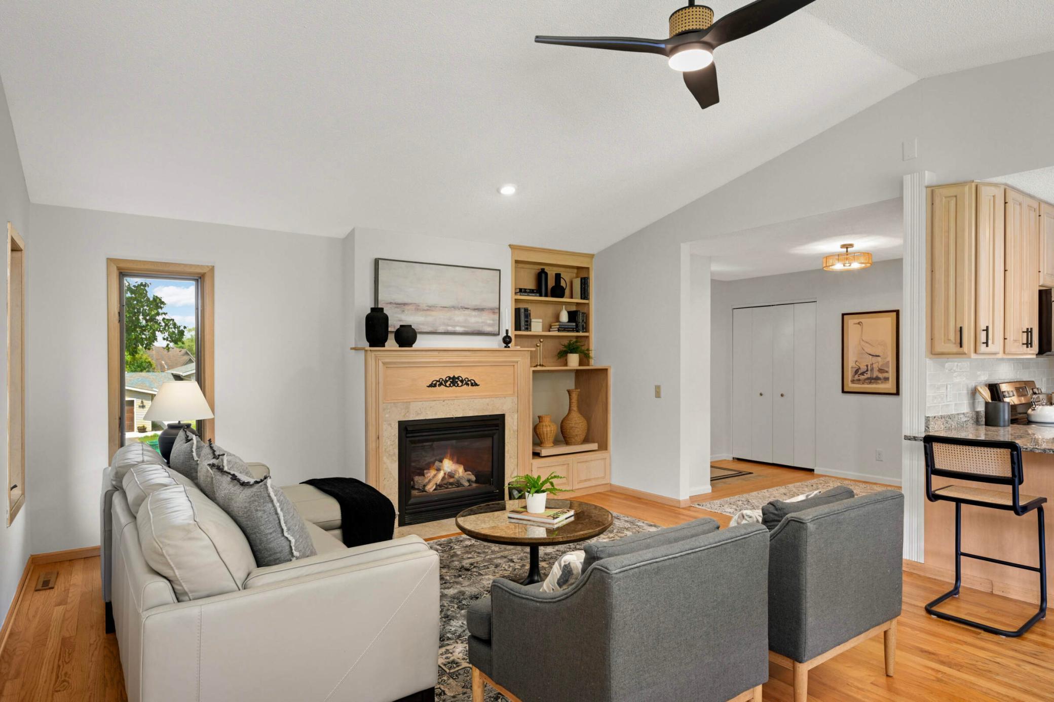 The Heat & Glo gas fireplace is framed by a wood mantle, convenient, built-ins, and a lovely natural stone surround.