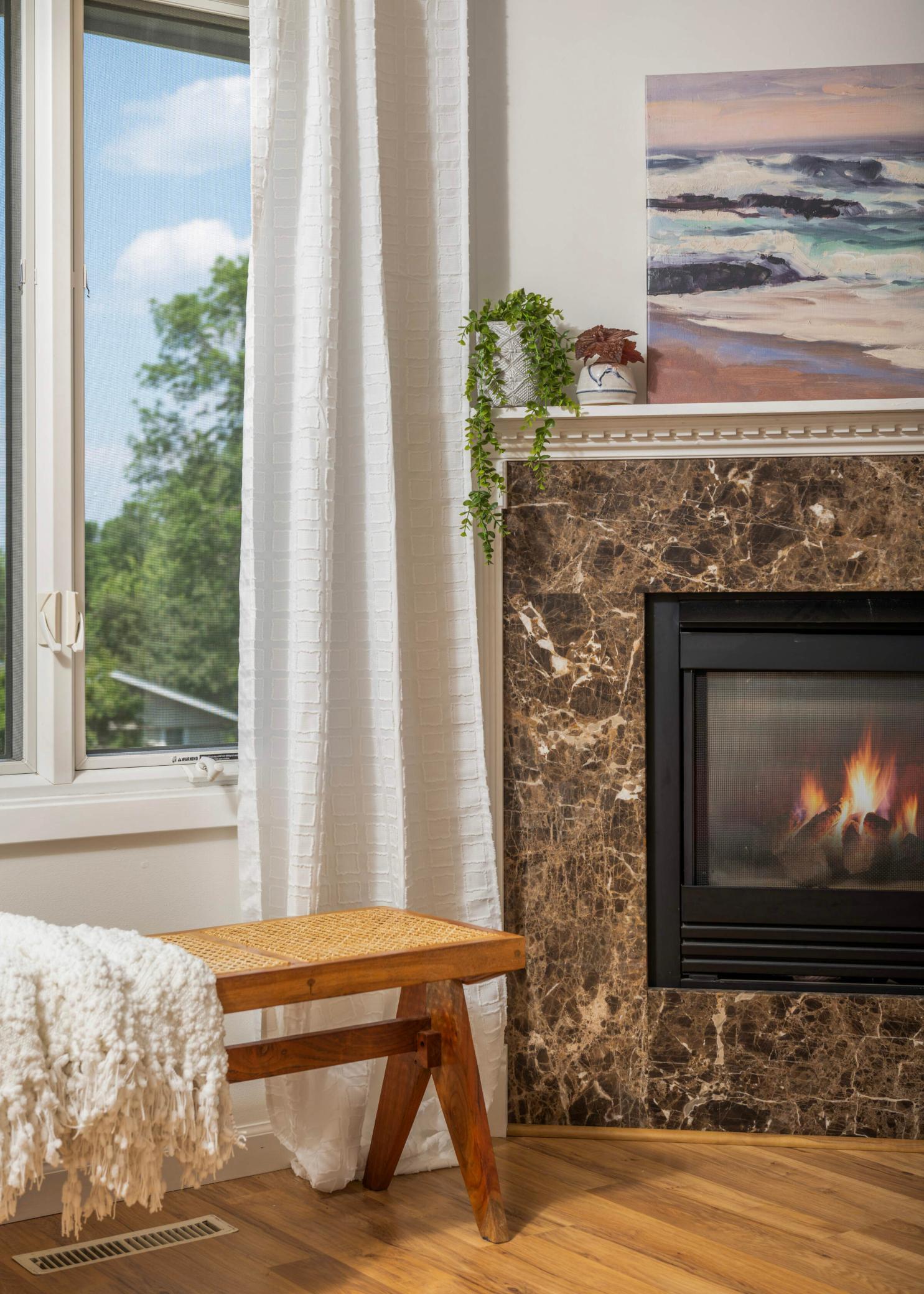 The gas fireplace with marron marble surround is a cozy and romantic feature of the primary suite.