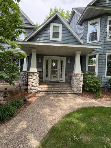 Grand Entrance with stone columns and an exposed aggregate side walk